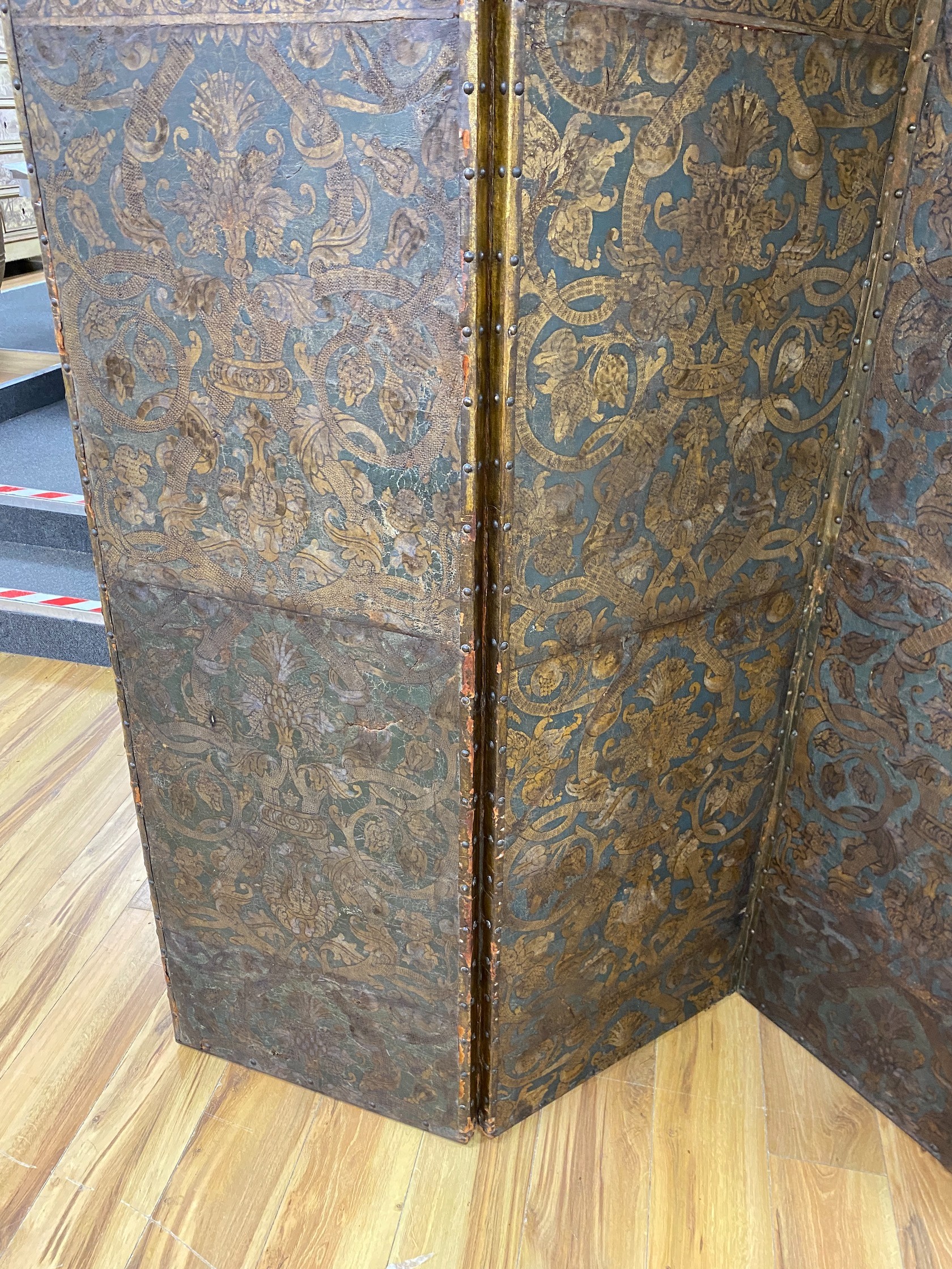 A 19th century French studded leather four fold screen, each panel width 49cm, height 182cm